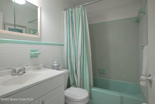 bathroom featuring a wainscoted wall, shower / tub combo with curtain, toilet, tile walls, and vanity