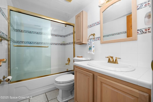 bathroom featuring vanity, enclosed tub / shower combo, tile patterned floors, toilet, and tasteful backsplash