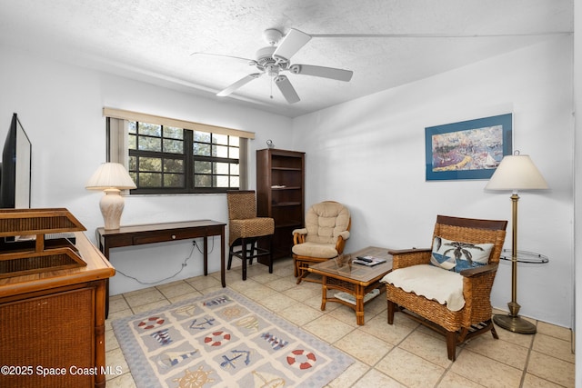 living area with a textured ceiling and ceiling fan