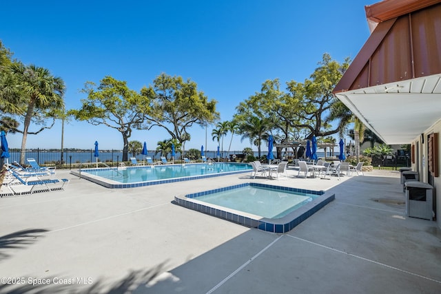 pool featuring fence, a hot tub, and a patio area