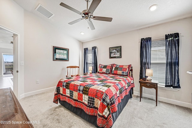 carpeted bedroom with baseboards, visible vents, ceiling fan, vaulted ceiling, and a textured ceiling