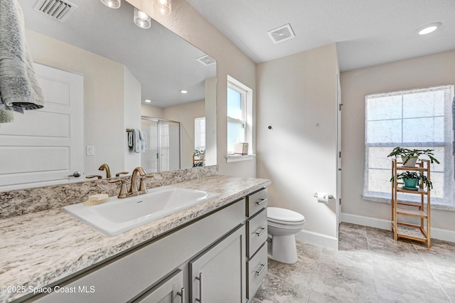 bathroom featuring a shower stall, visible vents, baseboards, and vanity