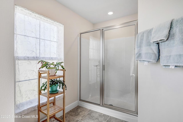 bathroom with tile patterned flooring, a shower stall, and baseboards