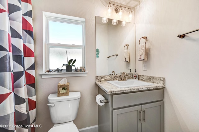 bathroom featuring a shower with shower curtain, vanity, and toilet