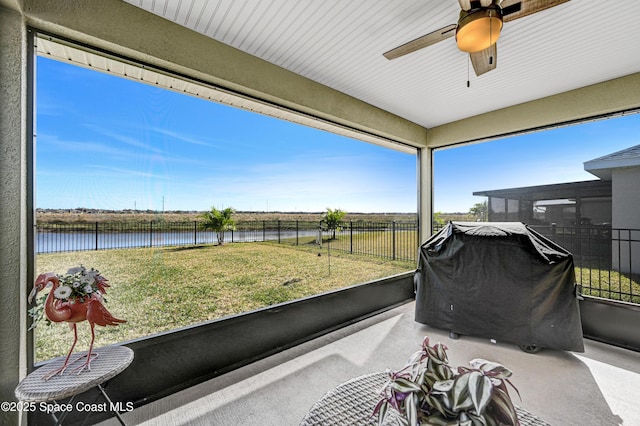 view of patio / terrace featuring a ceiling fan, fence private yard, a water view, and area for grilling