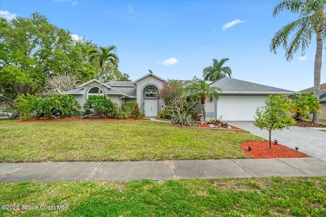 view of front of property featuring decorative driveway, a front yard, an attached garage, and stucco siding