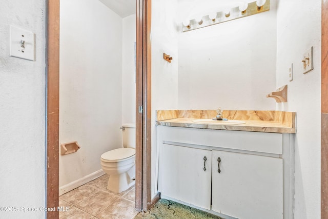 half bathroom featuring vanity, toilet, and tile patterned floors