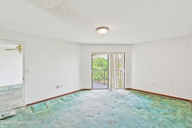 carpeted spare room with a textured ceiling and baseboards