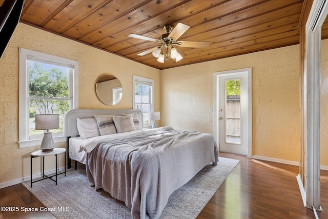 bedroom with wood ceiling, multiple windows, and a textured wall