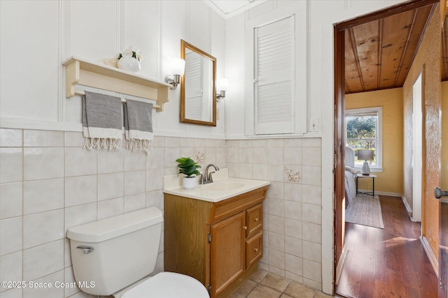 bathroom featuring tile walls, vanity, and toilet