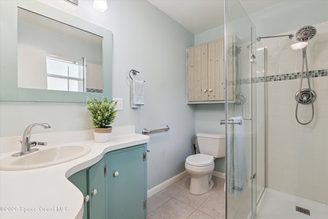 bathroom with tile patterned flooring, toilet, vanity, baseboards, and a shower stall