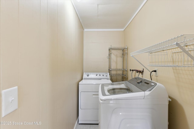 laundry room with laundry area, crown molding, and washing machine and clothes dryer