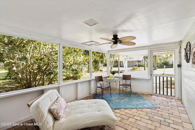 sunroom with a ceiling fan and a wealth of natural light