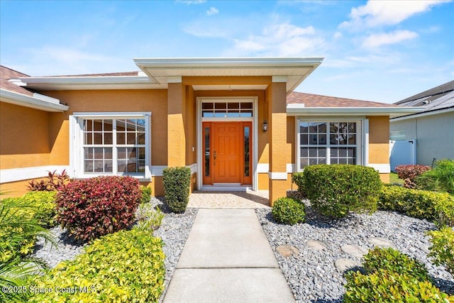 view of exterior entry featuring stucco siding