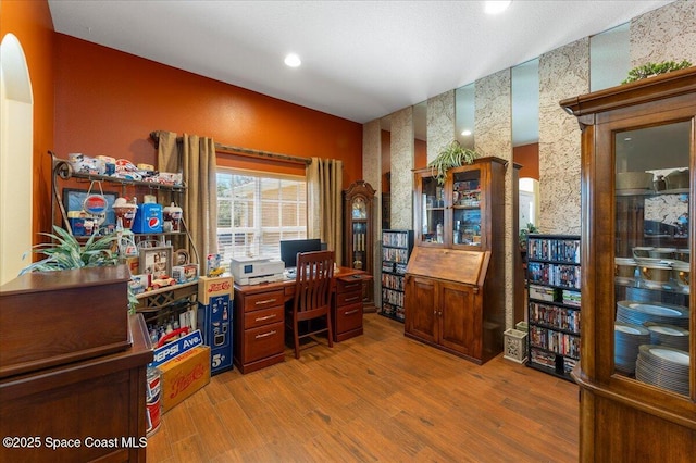 home office featuring recessed lighting, arched walkways, and wood finished floors