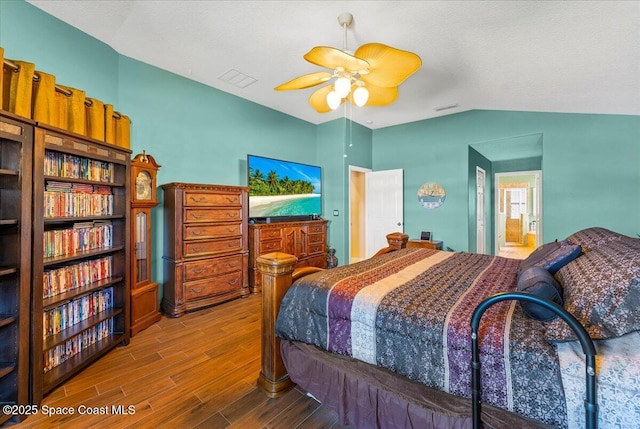 bedroom with lofted ceiling, visible vents, and wood finished floors