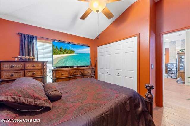 bedroom featuring vaulted ceiling, a closet, wood finished floors, and a ceiling fan