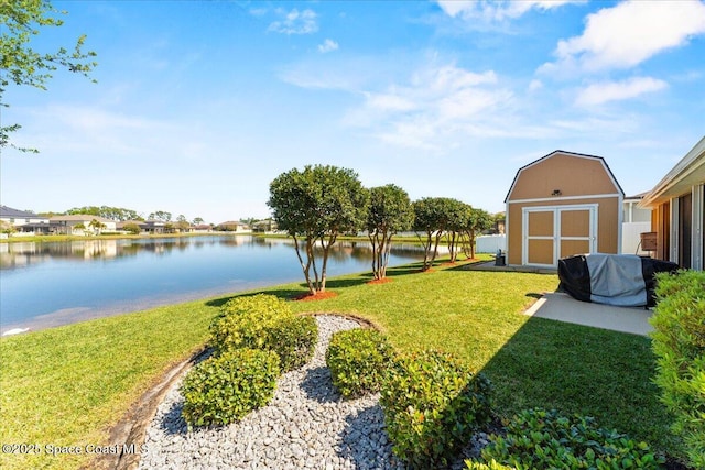 view of yard with an outbuilding, a shed, and a water view