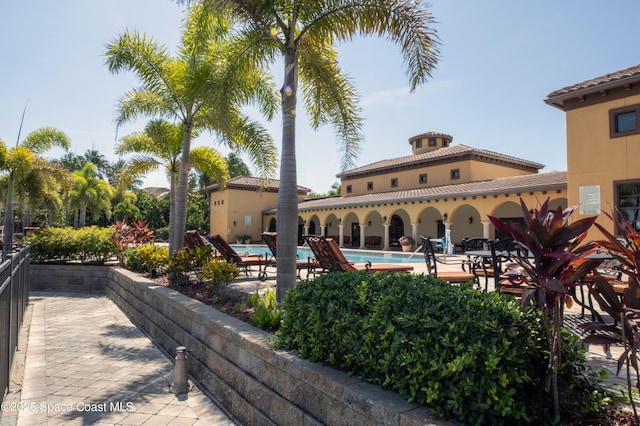 rear view of property featuring a patio area and a community pool