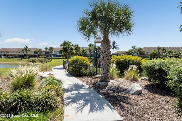 surrounding community featuring playground community, fence, and a residential view