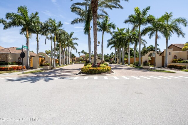 view of street with curbs, traffic signs, sidewalks, and a gate