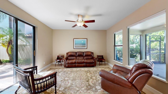 living area featuring ceiling fan and baseboards