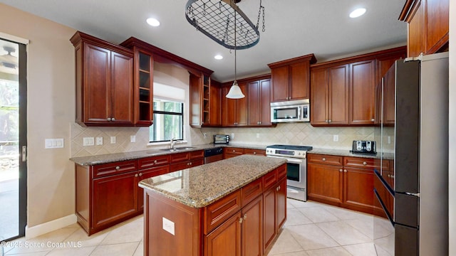 kitchen featuring light tile patterned floors, stainless steel appliances, a kitchen island, a sink, and light stone countertops