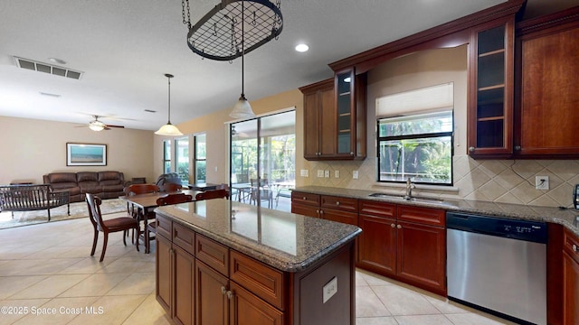 kitchen with light tile patterned flooring, a sink, visible vents, backsplash, and dishwasher