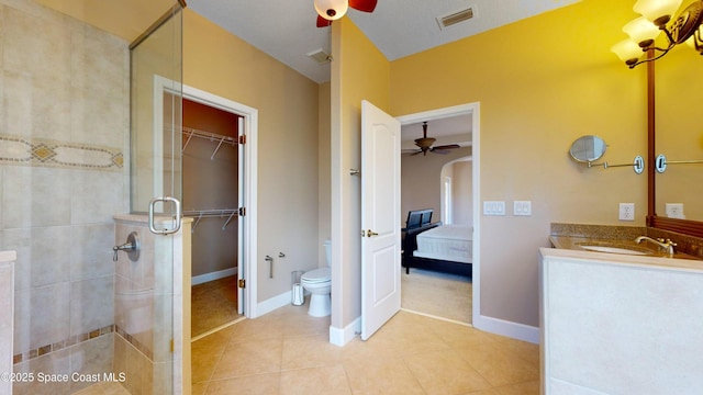 bathroom with a stall shower, visible vents, toilet, tile patterned floors, and vanity