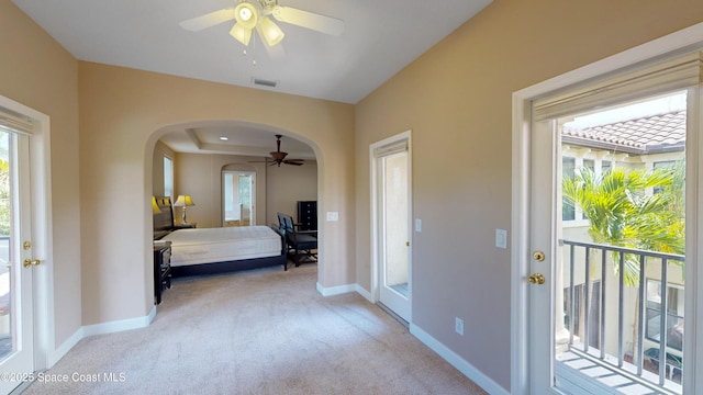 bedroom featuring arched walkways, light carpet, visible vents, and access to exterior