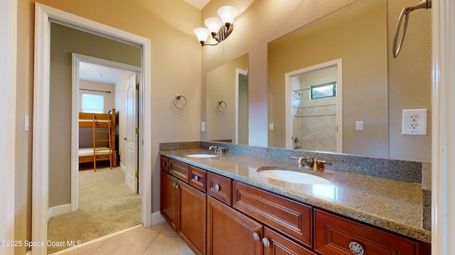 full bath with double vanity, tile patterned flooring, a shower, and a sink