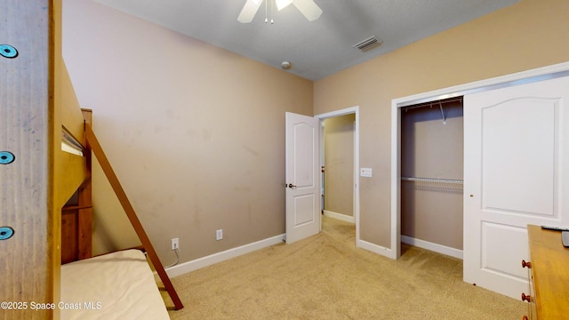 unfurnished bedroom with carpet, a closet, visible vents, ceiling fan, and baseboards