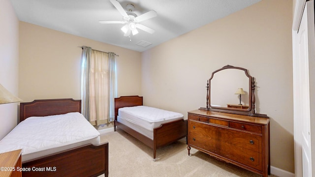 bedroom featuring visible vents, a ceiling fan, and light colored carpet