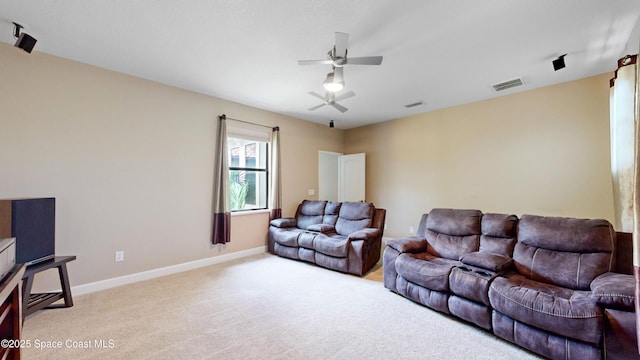 living room with baseboards, ceiling fan, visible vents, and light colored carpet