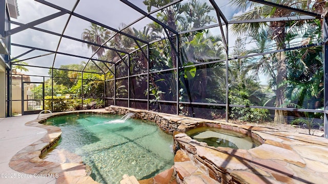 view of pool featuring glass enclosure, a patio, and a pool with connected hot tub