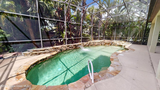 outdoor pool featuring glass enclosure and a patio