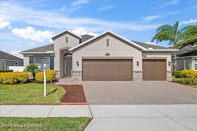 view of front of home with an attached garage, stone siding, decorative driveway, and stucco siding