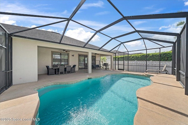 view of pool with a ceiling fan, a fenced in pool, glass enclosure, and a patio