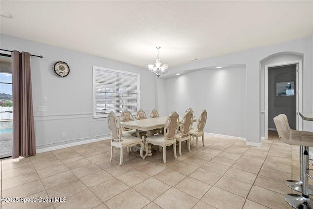 dining room with a chandelier, light tile patterned flooring, baseboards, and a healthy amount of sunlight