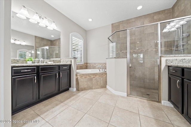 bathroom with a stall shower, tile patterned flooring, a garden tub, and vanity