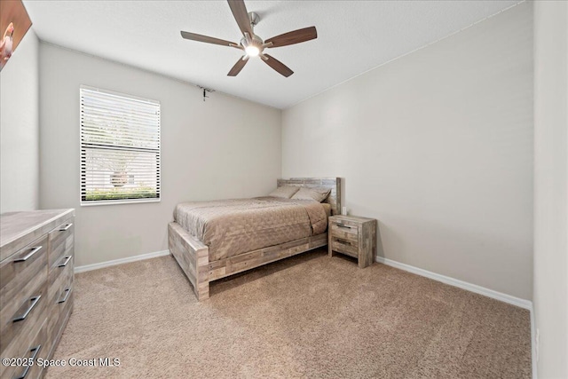 bedroom with light carpet, ceiling fan, and baseboards