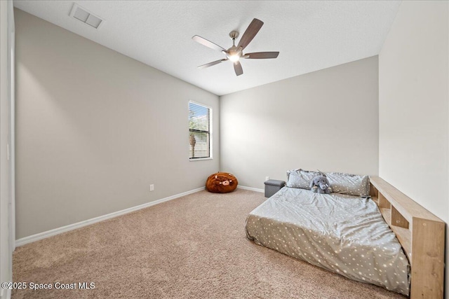 bedroom with a textured ceiling, carpet flooring, a ceiling fan, visible vents, and baseboards