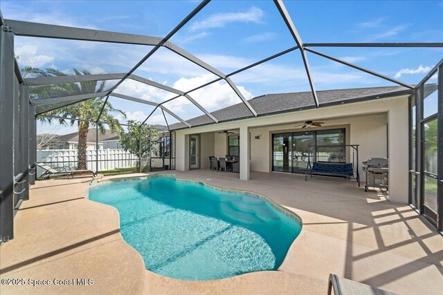 view of pool with a lanai, a patio area, ceiling fan, and a fenced in pool