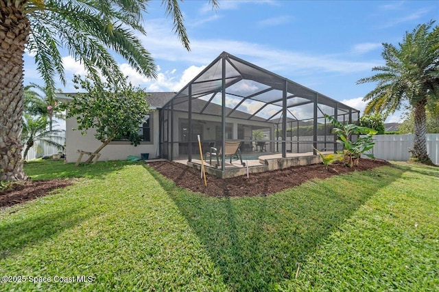 back of property featuring a lanai, stucco siding, fence, and a lawn