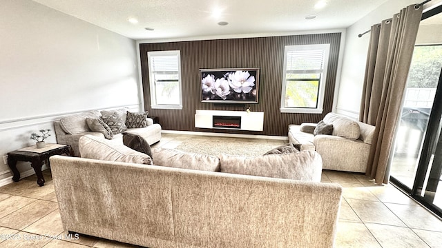 1216 Shiloh Dr, Melbourne, FL 32940 - living area featuring light tile patterned flooring, a lit fireplace, baseboards, and a textured ceiling