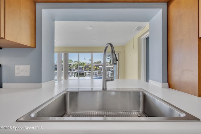 details with a sink, visible vents, and light countertops