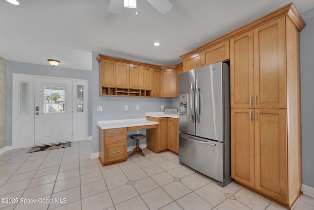 kitchen with open shelves, ceiling fan, light countertops, stainless steel refrigerator with ice dispenser, and built in desk