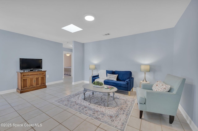 living area with light tile patterned floors, visible vents, baseboards, and a skylight