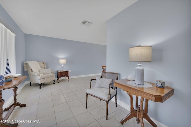 living area featuring light tile patterned flooring, visible vents, and baseboards