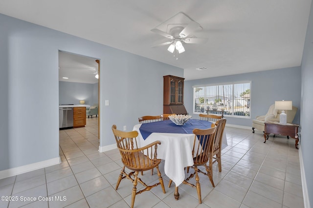 dining space with light tile patterned floors, a ceiling fan, visible vents, and baseboards
